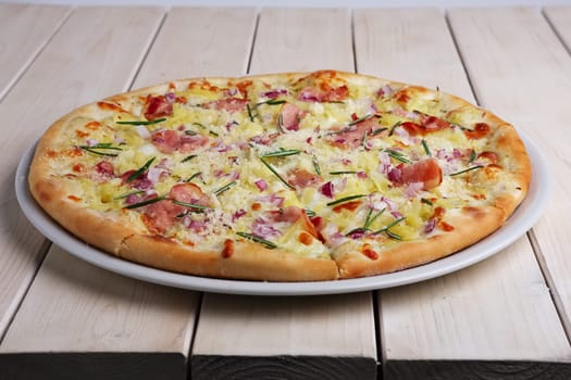 pizza with bacon chips, ham, cheese and rosemary