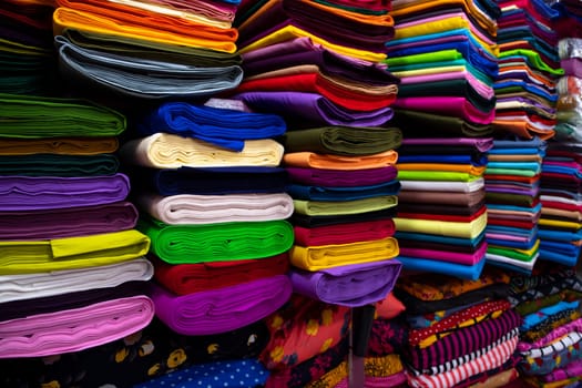 Artistic variety shade tone colors Textile Fabrics stacked on retail Shop Shelf to sale