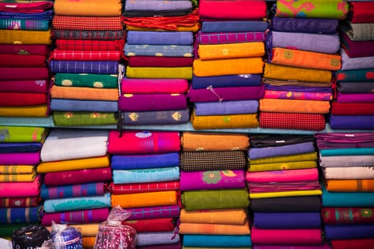 Artistic variety shade tone colors Saree's stacked on retail Shop Shelf to sale