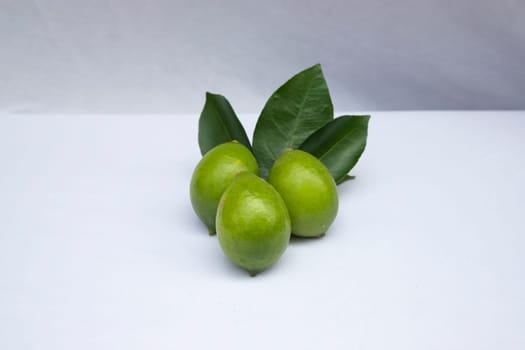 Fresh green lemon slice pieces with leaf. Testy lemon fruits. Refreshing summer drink ingredient