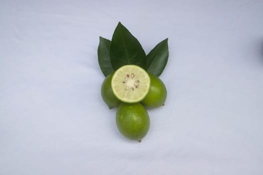 Fresh green lemon slice pieces with leaf. Testy lemon fruits. Refreshing summer drink ingredient