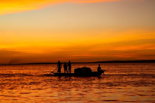 A Fishing boat  On Sea Against orange Sky During Sunset