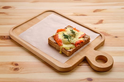 Sandwich with salmon, melted cheese and spicy sauce