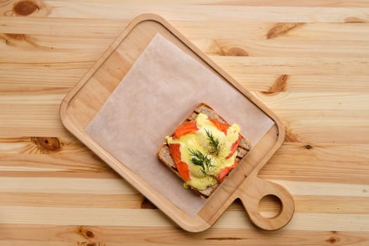 Sandwich with salmon, melted cheese and spicy sauce