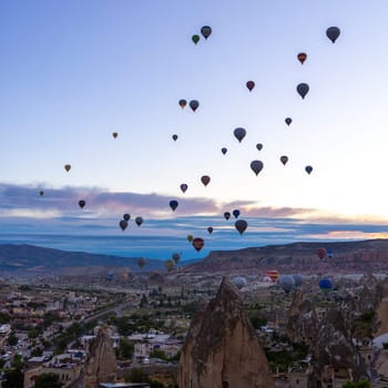 GOREME/TURKEY - June 27, 2022:several hot air balloons fly at dawn in the sky of goreme