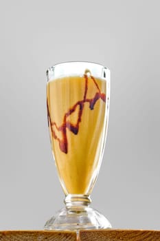 Low angle view of glass of banana smoothie on wooden table