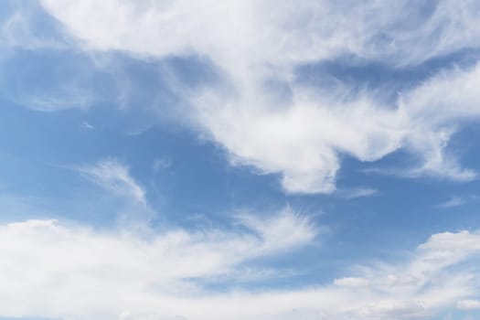 Blue sky background with white clouds. Concept of peace and tranquility.