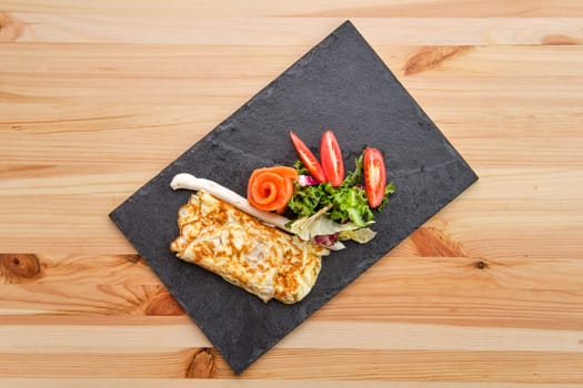 Omelette with salmon on slate plate