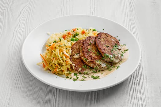 Plate with liver cutlet, rice with peas and pickled cabbage