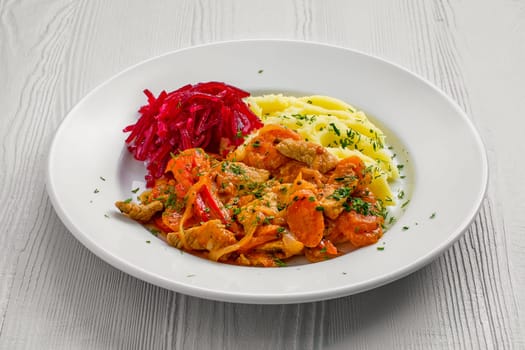 Plate with beef goulash, mashed potato and beetroot salad