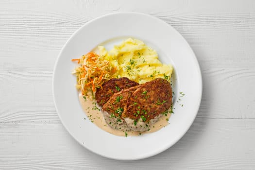 Top view of plate with liver cutlet,mashed potato and pickled cabbage