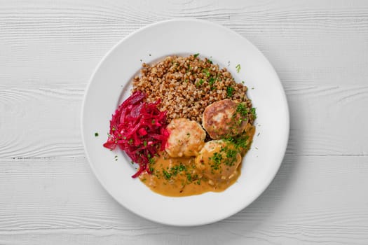 Top view of plate with meatballs, buckwheat and beetroot salad