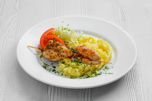 Plate with chicken shashlik, mashed potato and cabbage salad