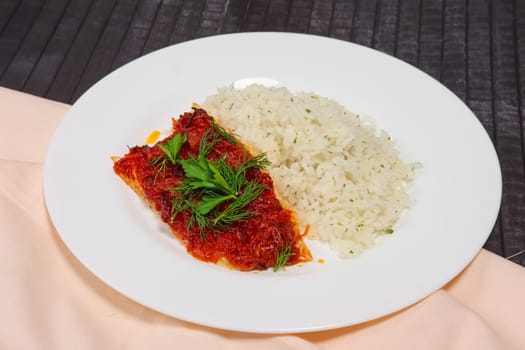 Fried with spices white sea fish served with rice and dill