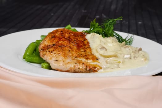 Closeup grilled steak and french green bean with creamy onion sauce.