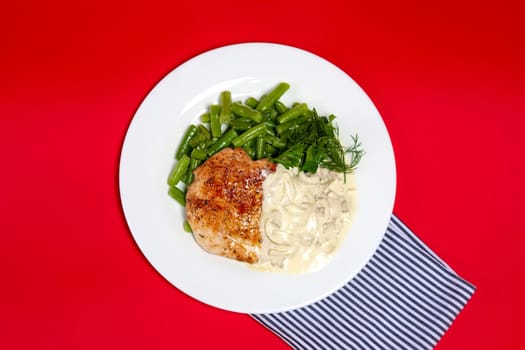 Top view of plate with grilled steak and french green bean with creamy onion sauce.