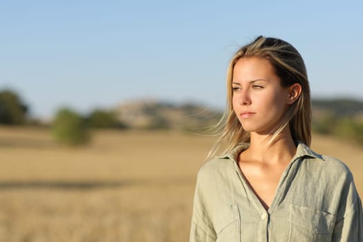 Serious woman in a field looking at side