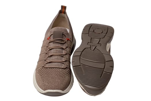 Closeup of a pair of modern brown sneakers or sports shoes isolated on a white background. Elegant and trendy mans shoes. Macro.