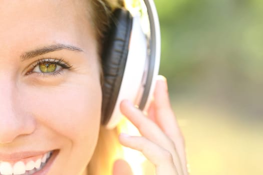 Front view portrait of a happy woman face listening to music with headphones looking at you