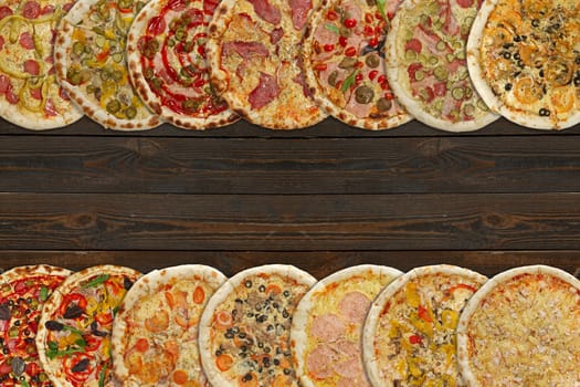 Horizontal collage of different baked pizzas on dark wooden table. Top view.