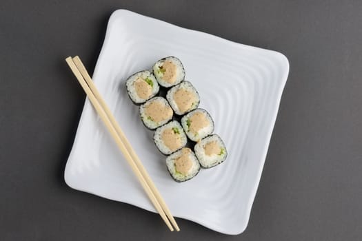 chicken roll with nori and nut sauce on white plate near hashi