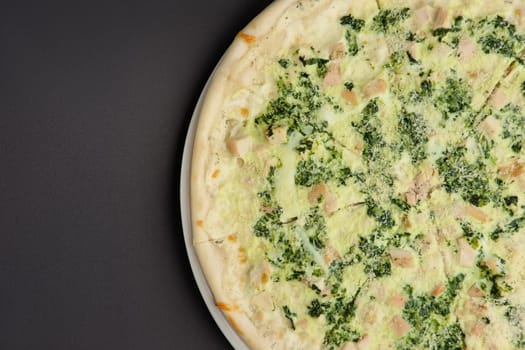 Top view of part of pizza with ham and mushroom on black background