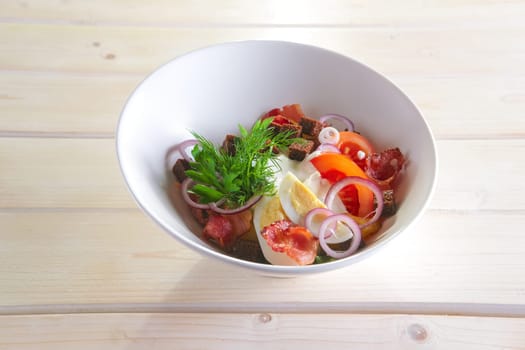 Country salad with fried potato, bacon, brown bread chips, egg, tomato and onion