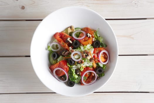 Salad with fried tomato, walnuts, cucumber, onion and olives