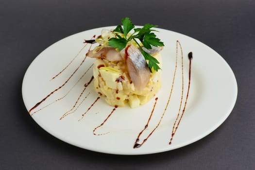 Top view of salad with herring, egg, apple and onion rings