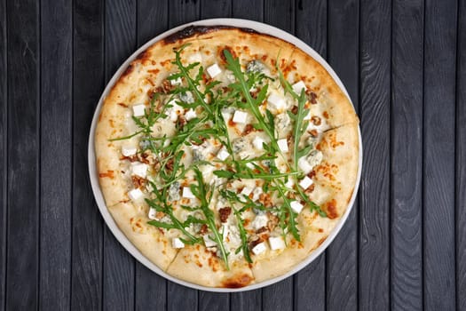 Top view of pizza with different kind of cheese with arugula