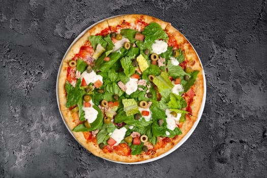 Top view of pizza with ham, feta cheese, anchovy and lettuce salad