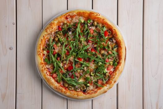Pizza with mushrooms, zucchini, bell pepper, onion and arugula