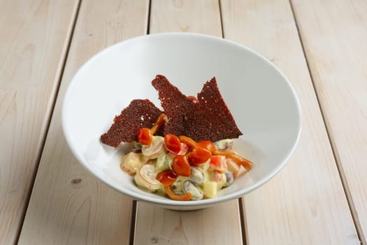 Salad with kidney beans, honey agaric, and brown bread chips