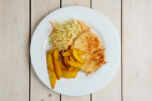 Chop cutlet with fried potato and fresh cabbage and carrot