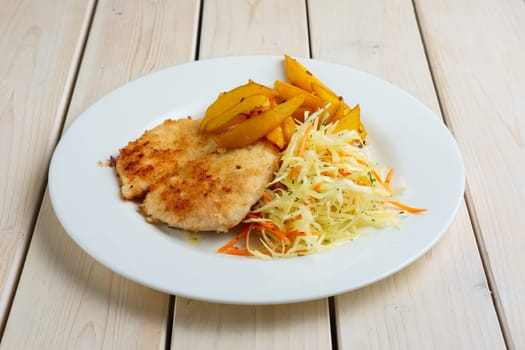 Chop cutlet with fried potato and fresh cabbage and carrot