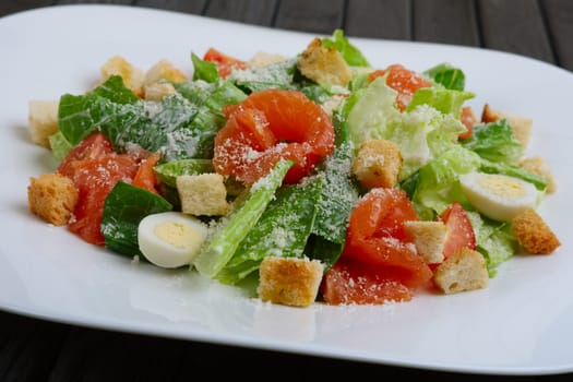 Close up photo of salad with quail egg, salmon and vegetables