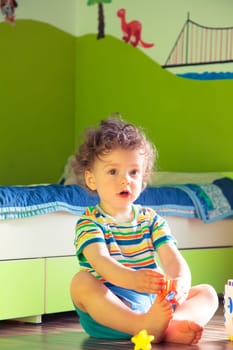 Portrait of 1 year old baby boy playing in his beautifully painted room.