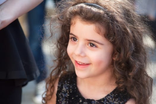 Portrait of 5 year old little girl with curly hair outdoor.