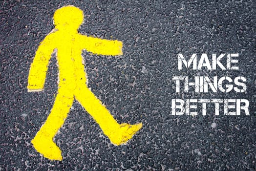 Yellow pedestrian figure on the road walking towards Make Things Better. Conceptual image with Text message over asphalt background.