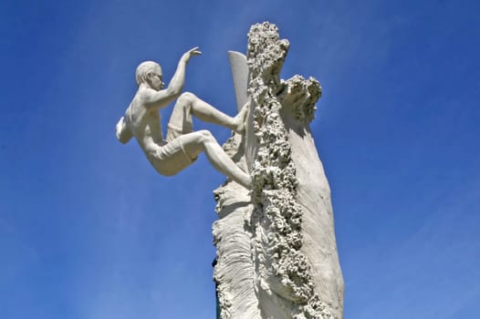 A surfer sand sculpture with blue sky