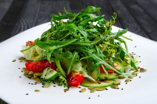 Salad of fresh avocado, cucumber, tomato cherry,  cabbage, lettuce and pumpkin seed sparged with vinegar