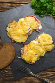 Baked in oven meat with mushrooms, tomato and cheese, servet on stone plate