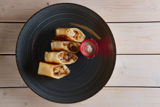 Thin pancakes with ham, bacon and barbecue sauce