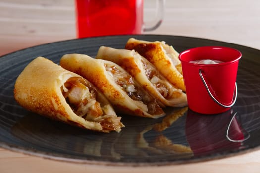 Thin pancakes with ham, bacon and barbecue sauce