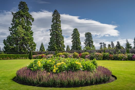 Circular flowerbed in beautiful Powerscourt garden with hedges, decorative trees, fountains and forest, Enniskerry, Wicklow, Ireland
