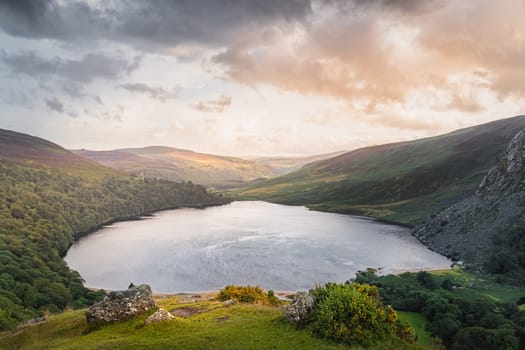 Beautiful and dramatic sunset at Lough Tay, called The Guinness Lake located in deep valley and surrounded by Wicklow Mountains, Ireland
