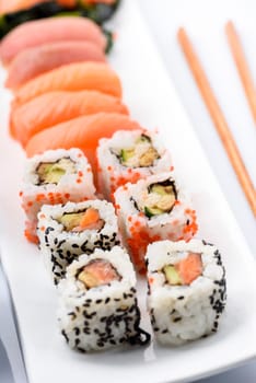 Sushi set with salmon and tuna fish with chopsticks in white plate. Traditional japanese cuisine.
