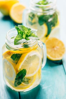 Mint lemonade in mason jars on retro blue wooden table