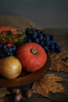 Happy thanksgiving holiday concept. Still life of autumn leaves, pumpkin, and fruits on rustic wooden table.