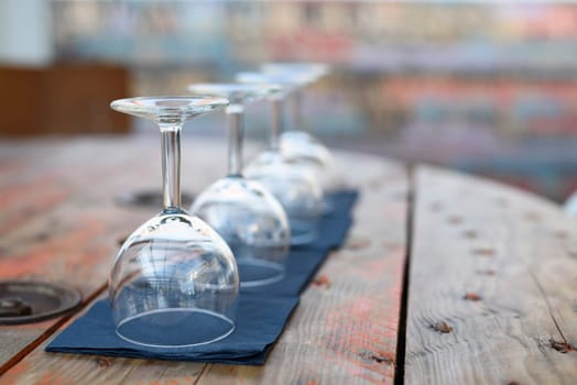 Empty wine glasses on rustic wooden table in retro restaurant interior.
